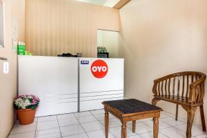 a chair sitting next to a refridgerator in a room at OYO 90949 Apartement Cibubur Village kaisar property Lobby B in Pedurenan Dua