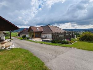 a house with a fence on the side of a road at Ferienwohnung Haiberg in Rudolfing