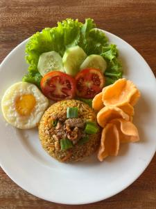 a white plate of food with an egg and vegetables at AK's Surf Resort in Wainapal +7 photos
