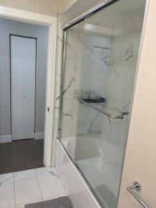a bathroom with a shower with a glass door at Cozy 3-Bedroom Retreat in Surrey Share Save in Surrey