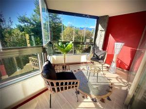 una veranda schermata con sedie e finestra di Departamento Refugio Vista al Volcán Pucón a Pucón