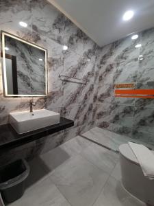 a bathroom with a sink and a toilet and a mirror at Eng Wan Hotel in Kamunting