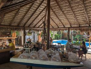 a group of people sitting at tables in a restaurant at Pousada Villa del Lótus in Itarema