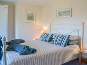 un letto con lenzuola e cuscini blu e bianchi di Barton Cottage a North Petherwin