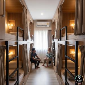 two people sitting in a room with bunk beds at THE PLACE Hostel Phnom Penh in Phnom Penh +3 photos