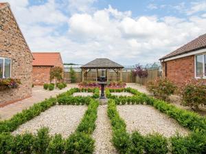 a garden with a gazebo in a house at Nursery Cottage in North Somercotes +3 photos