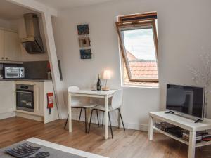 a small living room with a table and a television at Coast Apartment in Whitby