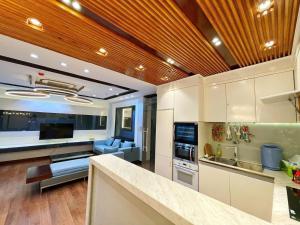 une cuisine avec des armoires blanches et un salon dans l'établissement ARIA Vũng Tàu - Thành Phố Vũng Tàu, à Xã Thắng Nhứt