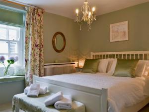 a bedroom with a bed and a chandelier at Betsy Cottage in Windermere