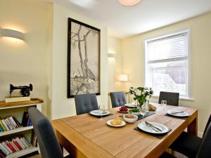 a dining room with a wooden table and chairs at Cornerstone in Castletown