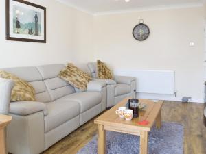 Una sala de estar con un sofá y una mesa de café. en Sea Dreams, en Saundersfoot
