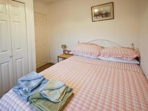 a bedroom with a bed with two towels on it at Maltings Cottage in Rothbury +3 photos