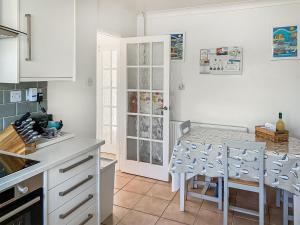 a kitchen with a counter and a table and chairs at September Cottage in Brancaster
