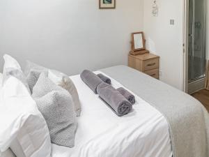 a white bed with towels on top of it at September Cottage in Brancaster