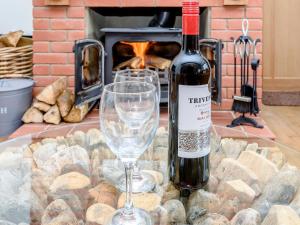 a bottle of wine and a glass on a table at Corner House in Cromer