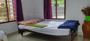 a small bed in a room with a window at White Sands Cottage in Alleppey