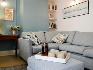 Una sala de estar con un sofá gris y una mesa. en Applegarth, en Cockermouth