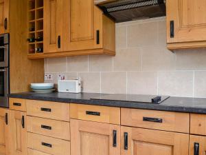 Una cocina con gabinetes de madera y encimera. en Applegarth, en Cockermouth 9 fotos más