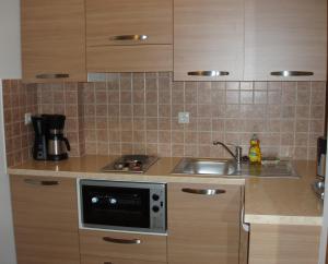 a kitchen with a sink and a microwave at Anastasia Studios in Avlemonas
