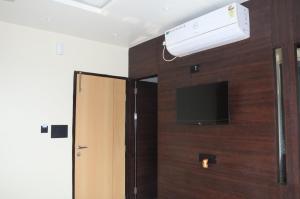 a room with a tv and a wall with a door at Fern Inn Hotel in Kolkata