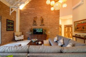 a living room with a couch and a brick wall at Sunset Paradise Villa Nusa Dua in Nusa Dua