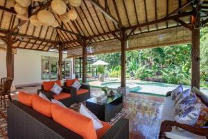 an outdoor living room with couches and a patio at Sunset Paradise Villa Nusa Dua in Nusa Dua