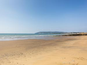 una playa de arena con un muelle en el océano en Downs View, en Sandown