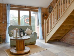 Una sala de estar con una silla y una mesa. en The Shieling, en Freshwater