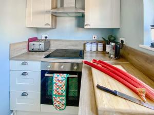 a kitchen with a counter top with a stove and a knife at Corner View in Broadstairs