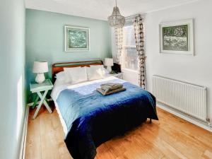 a bedroom with a bed with a blue blanket at Corner View in Broadstairs
