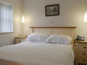 a bedroom with a bed with white sheets and pillows at Hollies Cottage 2 - Ukc4520 in Martock +5 photos