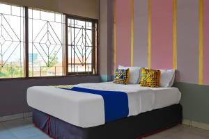a large bed in a room with two windows at Hotel O 92453 '139 Guest House in Bojongsoang