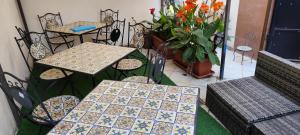 a patio with tables and chairs and a potted plant at Sea and Blue Sky 1A in Calimera