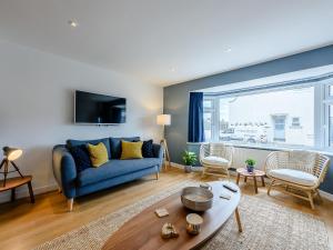 a living room with a blue couch and a window at Ocean Beach in Felpham