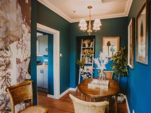 a dining room with blue walls and a wooden table at Rose Blair Lodge - Uk31045 in Portpatrick