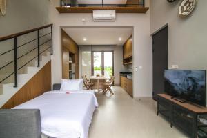 a bedroom with a bed and a table and a tv at Nusa Djiwa in Tanah Lot