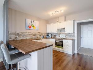 a kitchen with white cabinets and a wooden counter top at Cottage 6 - Uk38217 in Ashby cum Fenby