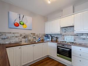 a kitchen with white cabinets and a sink at Cottage 6 - Uk38217 in Ashby cum Fenby