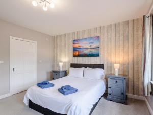 a bedroom with two blue towels on a bed at Cottage 6 - Uk38217 in Ashby cum Fenby +5 photos