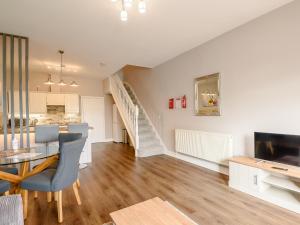 a living room with a dining room table and a staircase at Cottage 8 - Uk38219 in Ashby cum Fenby