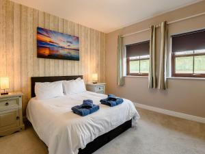a bedroom with a bed with two towels on it at Cottage 8 - Uk38219 in Ashby cum Fenby +9 photos