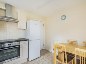 a kitchen with a white refrigerator and a wooden table at Country View - Uk38223 in Ashby cum Fenby
