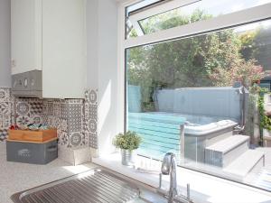 a kitchen with a sink and a window with a tub at Harbour Retreat in Paignton +18 photos