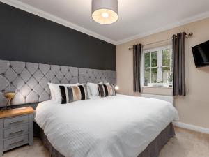 una camera da letto con un grande letto bianco e una finestra di Partridge Cottage a Kirk Leavington