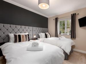 una camera da letto con due letti con asciugamani sopra di Partridge Cottage a Kirk Leavington Altre 13 foto