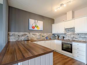 a kitchen with white cabinets and a wooden counter top at Cottage 7 - Uk38218 in Ashby cum Fenby