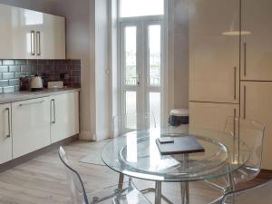 Una cocina con una mesa de cristal y sillas. en Charlotte Street, en Ayr