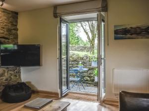 a living room with a sliding glass door leading to a patio at 1, The Barns in Threlkeld