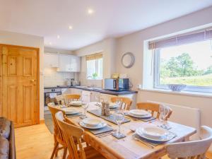 a kitchen and dining room with a wooden table and chairs at 1, The Barns in Threlkeld