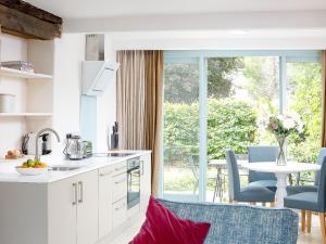 a kitchen with white cabinets and a table with chairs at The Hall - Uk32690 in Horton